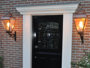 Klassiek koperen buitenlampen bij een mooie voordeur