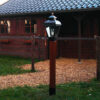 kleine RVS lamp op een houten paal